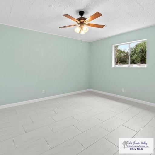 tiled spare room featuring ceiling fan