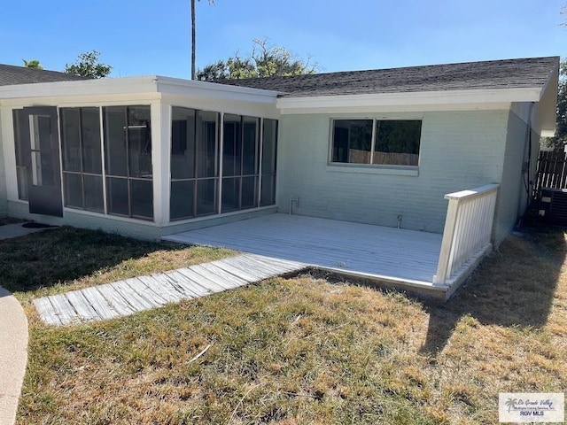 rear view of house featuring a sunroom, central air condition unit, a deck, and a lawn