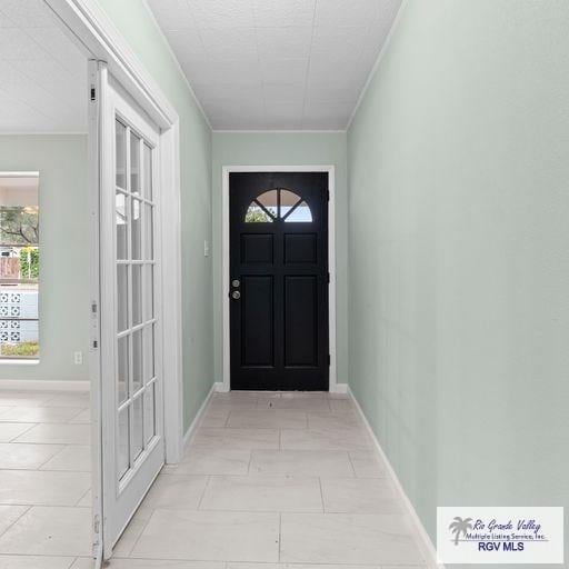 doorway to outside featuring crown molding