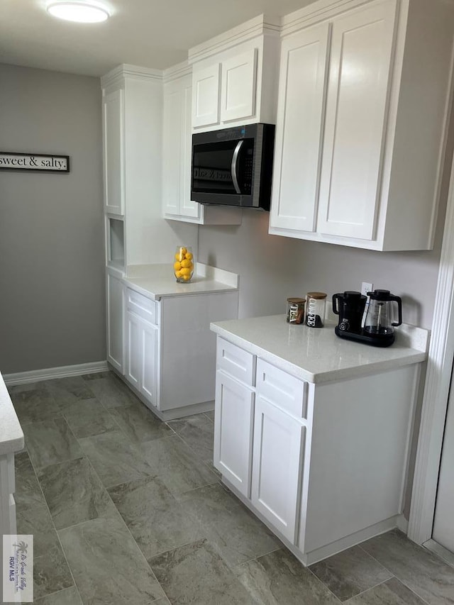 902 Rio Hondo Rd, Harlingen, TX 78550 - kitchen featuring white cabinets, light countertops, and baseboards