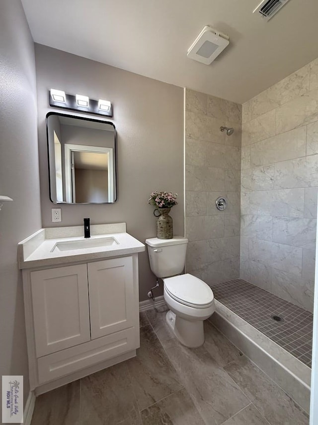 902 Rio Hondo Rd, Harlingen, TX 78550 - bathroom with toilet, tiled shower, marble finish flooring, vanity, and baseboards