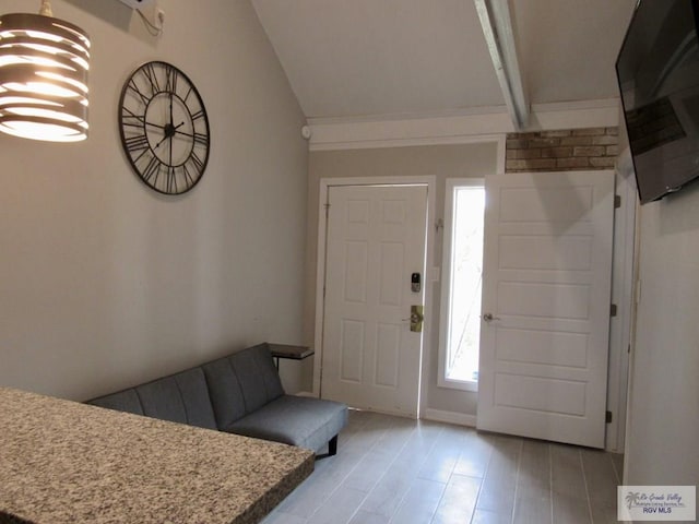 foyer featuring light hardwood / wood-style flooring, lofted ceiling, and a notable chandelier