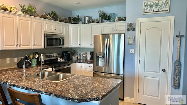 kitchen featuring white cabinets, appliances with stainless steel finishes, tasteful backsplash, and kitchen peninsula