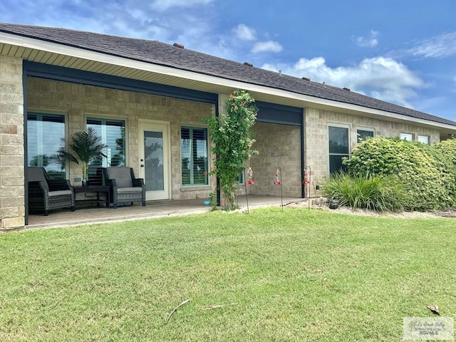 back of house with a lawn and a patio