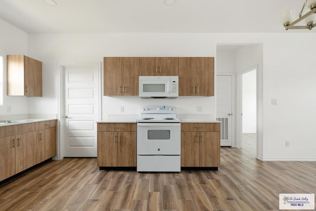 kitchen with dark hardwood / wood-style flooring, white appliances, and sink