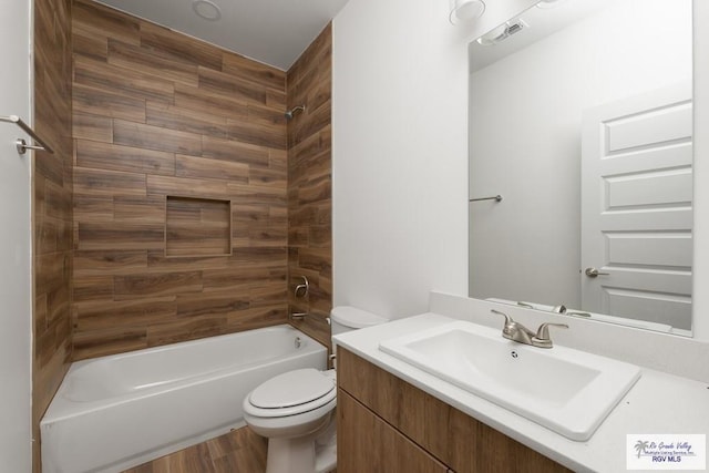 full bathroom with hardwood / wood-style flooring, vanity, toilet, and washtub / shower combination