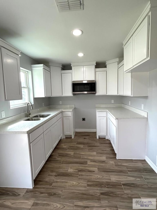 kitchen featuring stainless steel microwave, visible vents, recessed lighting, dark wood-style floors, and a sink