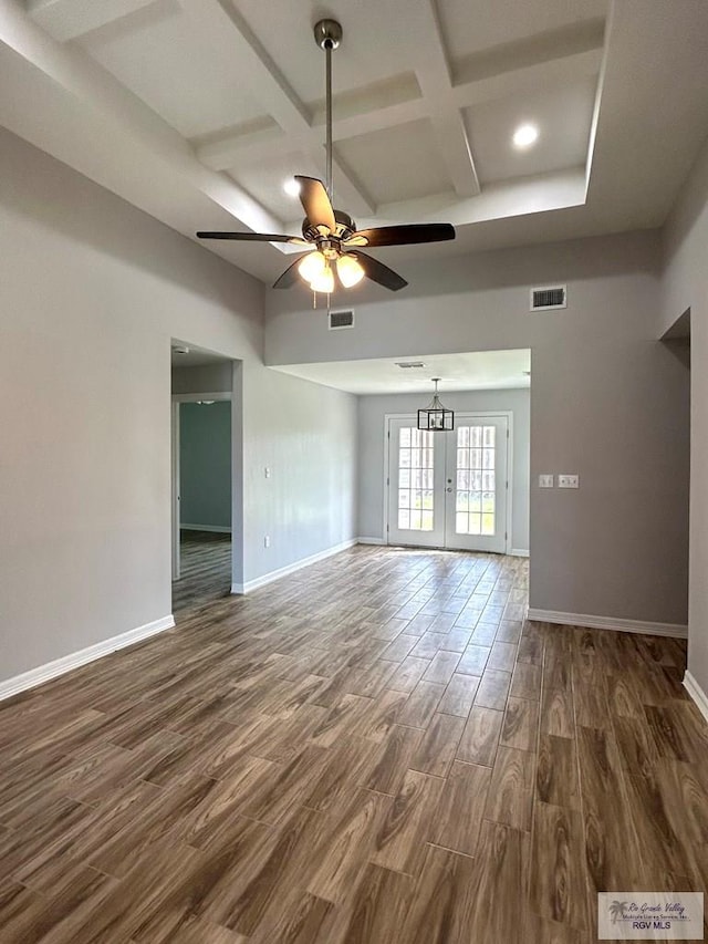 unfurnished room with visible vents, baseboards, coffered ceiling, and dark wood finished floors