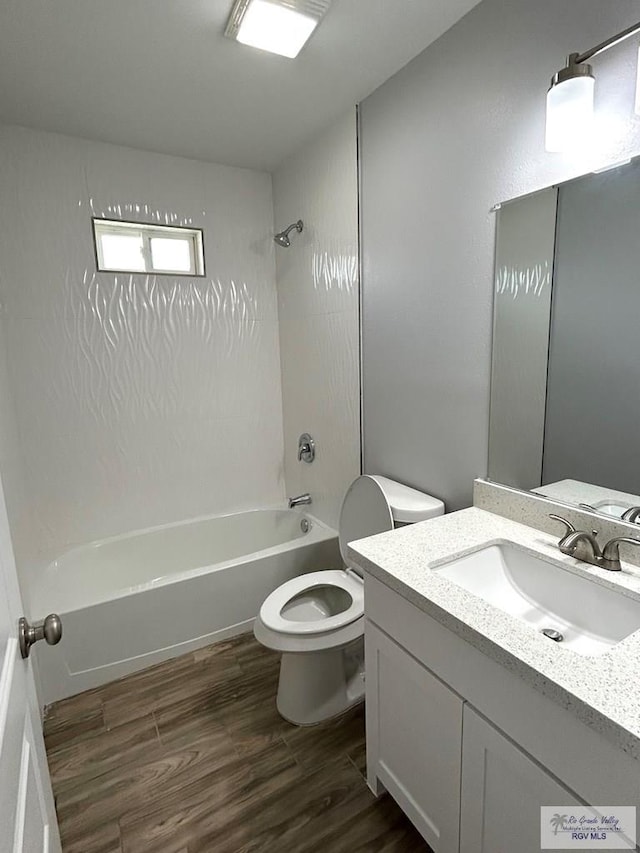 full bathroom featuring toilet, washtub / shower combination, vanity, and wood finished floors