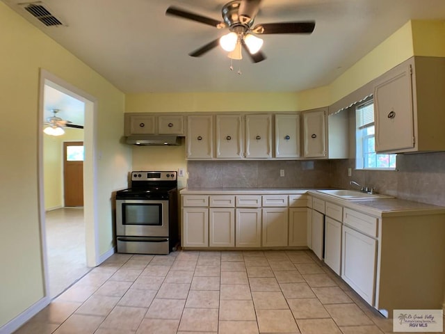 205 W Beck Ave, Harlingen, TX 78550 - kitchen featuring stainless steel range with electric stovetop, ceiling fan, light countertops, backsplash, and under cabinet range hood