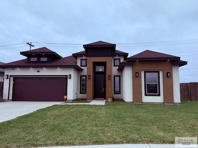 prairie-style house featuring a garage and a front yard