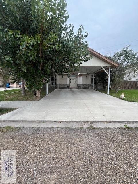 1972 Baja Cir, Los Fresnos, TX 78585 - view of front of house featuring driveway, stone siding, and an attached carport