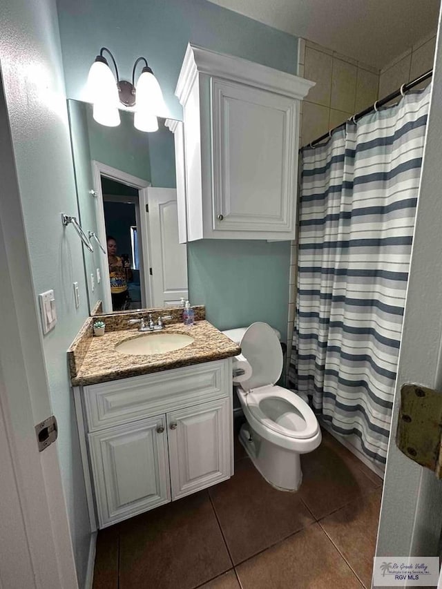 bathroom featuring walk in shower, tile patterned floors, toilet, and vanity