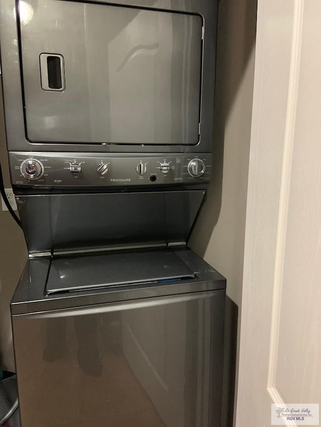 clothes washing area featuring stacked washer / drying machine