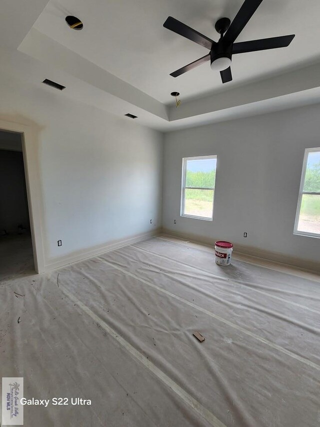 9848 Heights N, Harlingen, TX 78552 - spare room featuring a tray ceiling, plenty of natural light, a ceiling fan, and baseboards