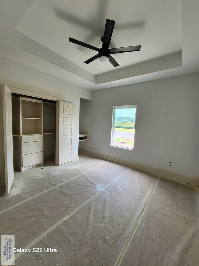 9848 Heights N, Harlingen, TX 78552 - unfurnished bedroom with a tray ceiling, a closet, and a ceiling fan