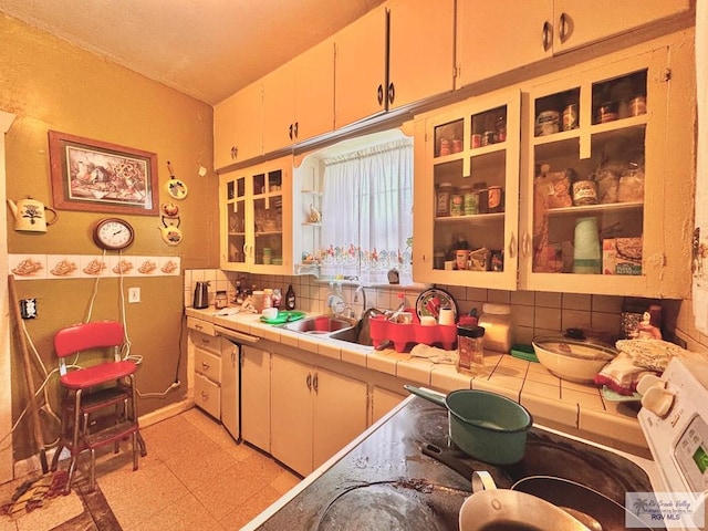 kitchen featuring tile counters, sink, and tasteful backsplash