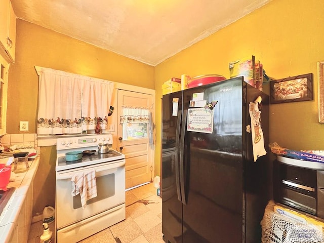 kitchen featuring white range with electric cooktop, tile counters, and black refrigerator with ice dispenser