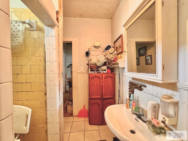 bathroom featuring a textured ceiling, tile patterned floors, and tile walls