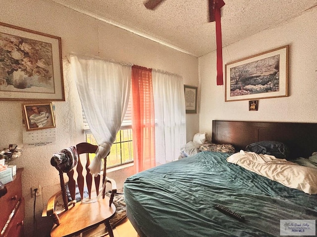 bedroom with ceiling fan and a textured ceiling