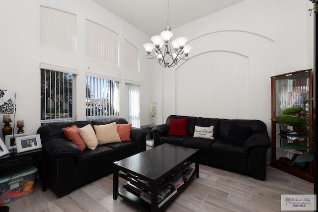 living area featuring a chandelier, wood tiled floor, and a towering ceiling