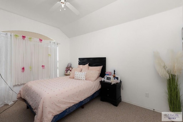 carpeted bedroom with vaulted ceiling and a ceiling fan