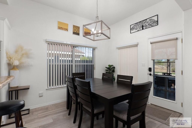 dining area featuring baseboards, plenty of natural light, an inviting chandelier, and light wood-style floors