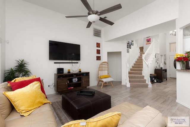 living room featuring visible vents, ceiling fan, stairway, and wood finished floors