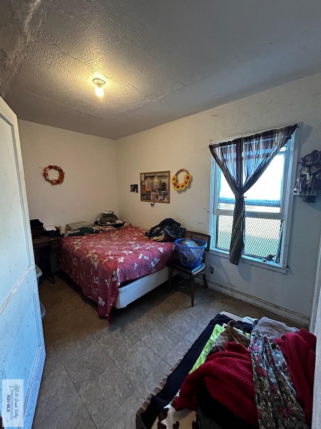 tiled bedroom with a textured ceiling