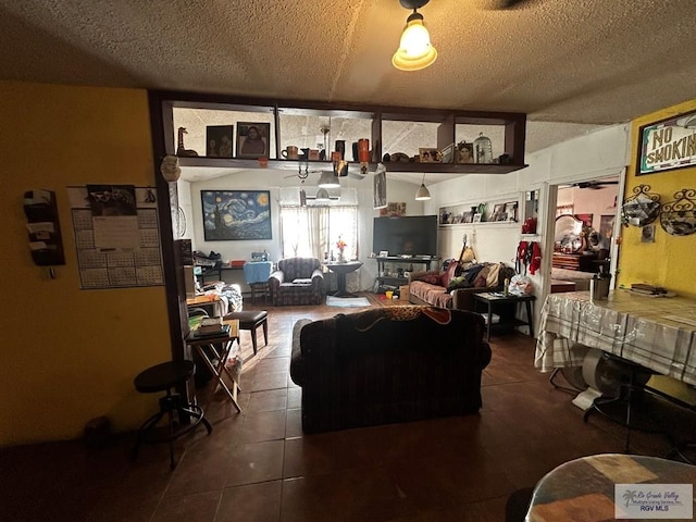 living room with a textured ceiling and dark tile patterned flooring