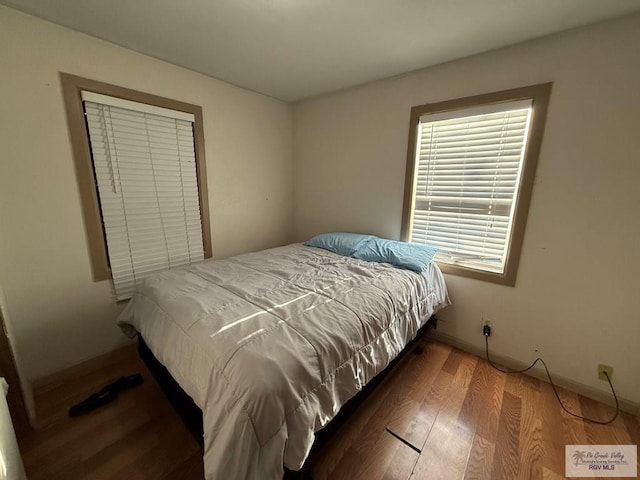 bedroom with baseboards and wood finished floors