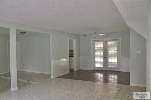 1725 Peach Tree Ct, Harlingen, TX 78550 - spare room featuring a textured ceiling, french doors, wainscoting, light tile patterned floors, and a ceiling fan