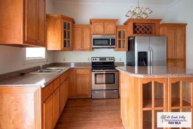 kitchen with sink, an inviting chandelier, light hardwood / wood-style flooring, appliances with stainless steel finishes, and pendant lighting