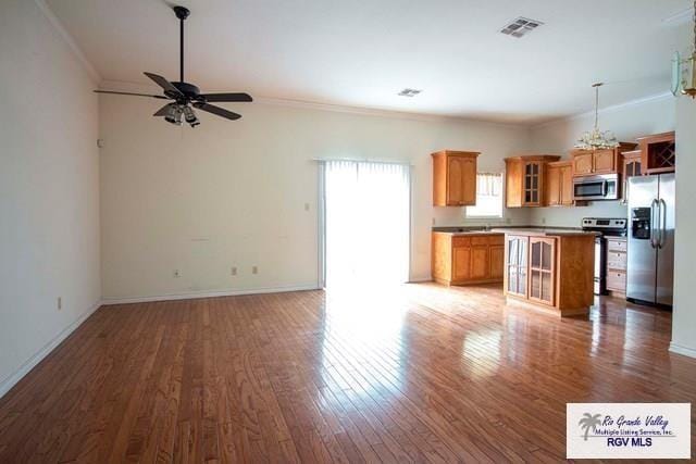 kitchen featuring crown molding, hardwood / wood-style flooring, a center island, and appliances with stainless steel finishes