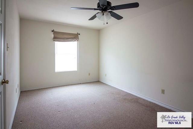 carpeted empty room featuring ceiling fan