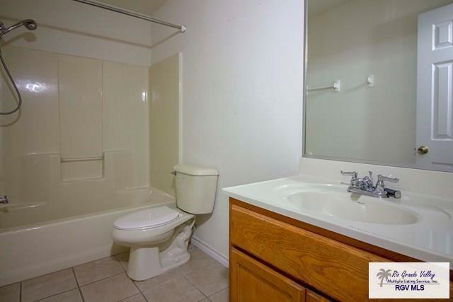 full bathroom featuring vanity, tile patterned floors, toilet, and washtub / shower combination