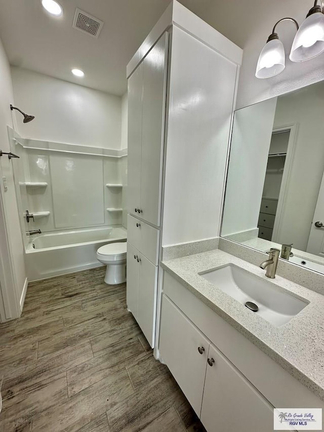 full bathroom with vanity, hardwood / wood-style floors,  shower combination, and toilet