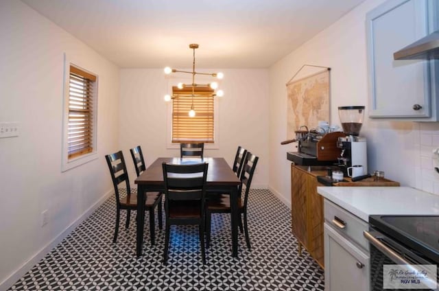 dining room with baseboards and a chandelier