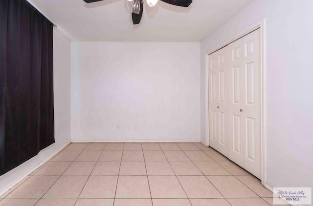 unfurnished bedroom with a closet, light tile patterned flooring, and a ceiling fan