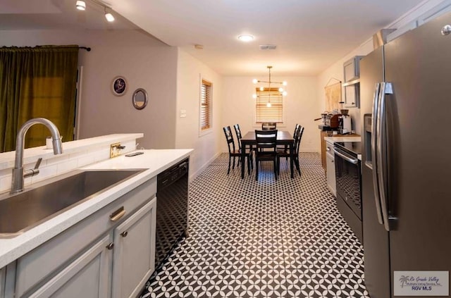 kitchen featuring range with electric stovetop, a sink, light countertops, dishwasher, and stainless steel fridge