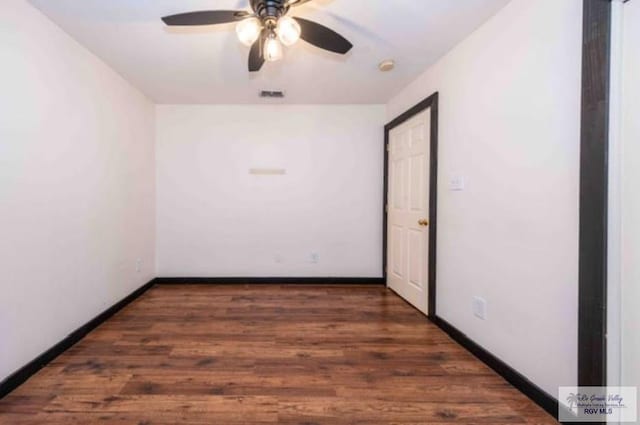 empty room featuring a ceiling fan, wood finished floors, visible vents, and baseboards