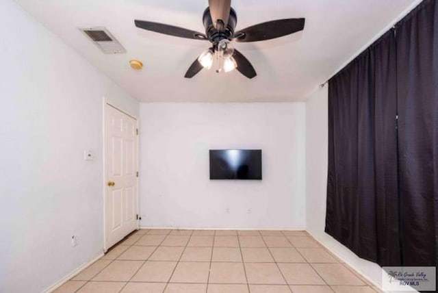 spare room featuring a ceiling fan, visible vents, and light tile patterned floors