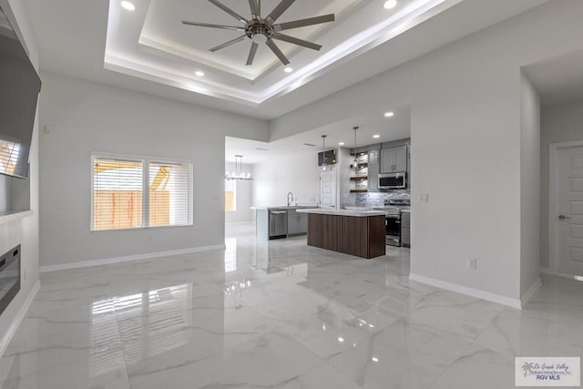 unfurnished living room featuring baseboards, recessed lighting, and ceiling fan with notable chandelier
