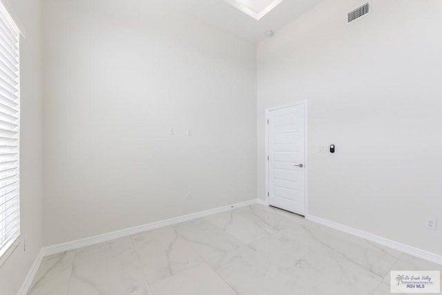 spare room with baseboards, visible vents, and marble finish floor