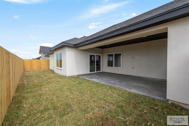 back of house with a patio, a yard, stucco siding, and a fenced backyard