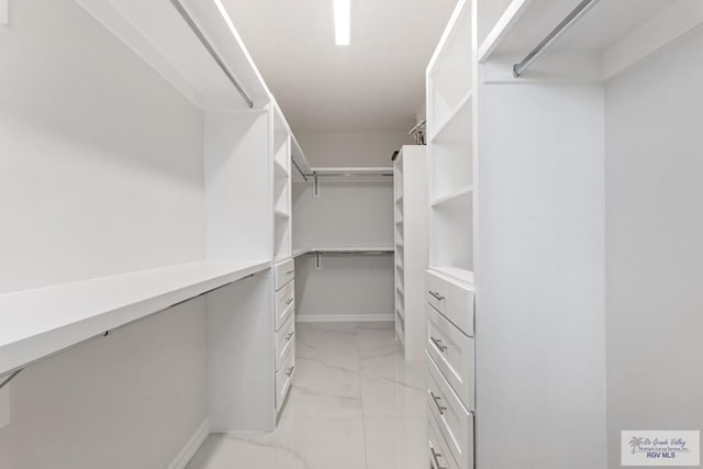 walk in closet with marble finish floor