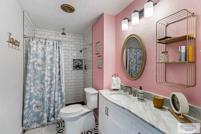 bathroom featuring a shower with shower curtain, vanity, and toilet