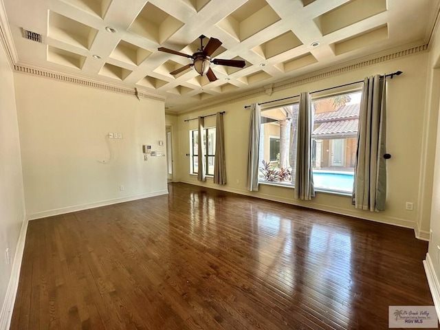 empty room featuring dark wood-type flooring, a healthy amount of sunlight, and coffered ceiling