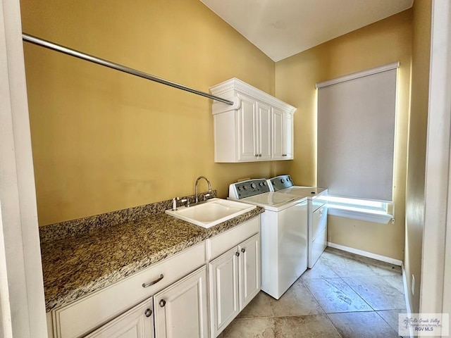 clothes washing area featuring sink, cabinets, and independent washer and dryer