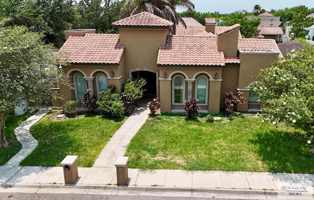 mediterranean / spanish-style house featuring a front yard